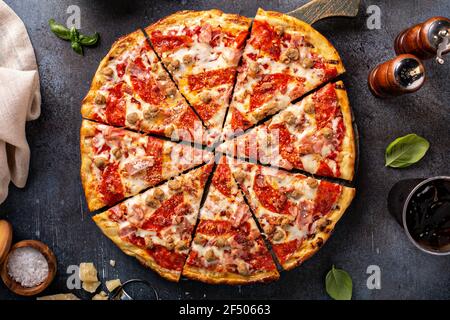 Pizza a base di carne con pepperoni, prosciutto e salsiccia Foto Stock