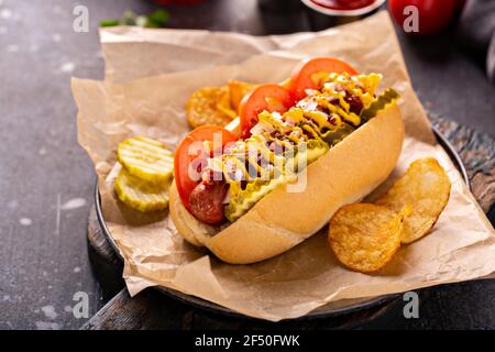 Hot dog con pomodori, senape e sottaceti Foto Stock