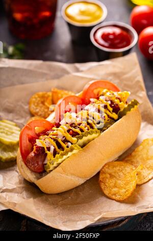 Hot dog con pomodori, senape e sottaceti Foto Stock