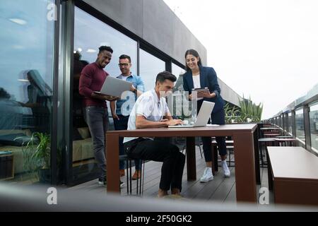 Gli uomini d'affari che lavorano con notebook e tablet digitale sul balcone Foto Stock