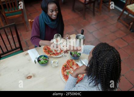 Madre e figlia gustano vino e pizza al ristorante tabella Foto Stock