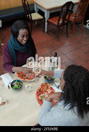 Madre e figlia gustano il vino con il pranzo al tavolo del ristorante Foto Stock