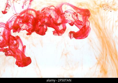 Modello astratto che cade nella goccia d'acqua di giallo e. inchiostro rosso Foto Stock
