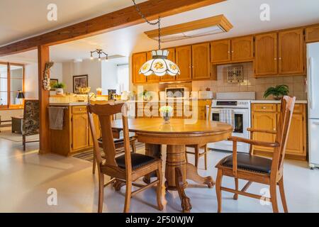 Tavolo da pranzo in legno di pino rosso artiglio con rovere rosso sedie in legno e pelle nera schienale alto in cucina con mobili in legno di quercia Foto Stock