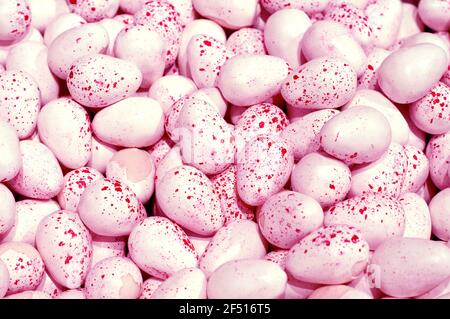 Sfondo di uova di cioccolato rosa. Sfondo di Pasqua. Vista dall'alto. Uova di Pasqua macchiate Foto Stock