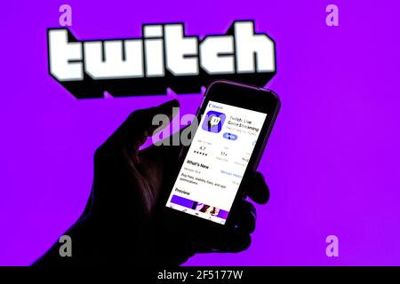 In questa illustrazione fotografica l'app Twitch in App Store Visualizzato sullo schermo di uno smartphone e sul logo Twitch sullo sfondo Foto Stock