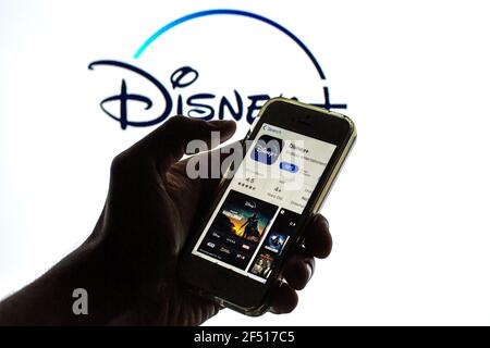 In questa illustrazione della foto, l'app Disney+ in App Store Visualizzato sullo schermo di uno smartphone e sul logo Disney+ sullo sfondo Foto Stock
