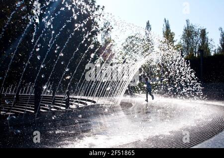 Krasnodar, Russia - 6 ottobre 2020: 'Krasnodar' Park o 'Galitsky Park' UNA bambina corre allegramente sotto i corsi d'acqua della fontana della città Foto Stock