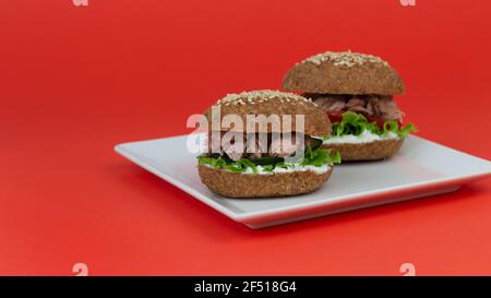 Sandwich Keto con tonno, lattuga, cetriolo fresco e fette di pomodoro. Il pane è fatto con farina di mandorle e psyllium. Menu dieta sana chetogenica. Foto Stock