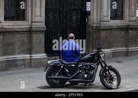 Uomo seduto su Harley-Davidson in strada. Foto Stock