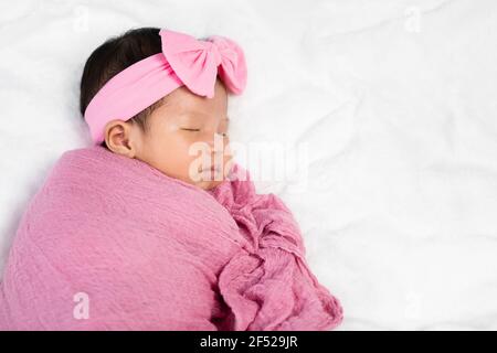 il bambino neonato dorme in coperta di tessuto rosa su un letto Foto Stock