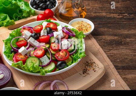 Insalata greca, olive e burro su sfondo ligneo. Vista laterale con spazio per la copia. Foto Stock