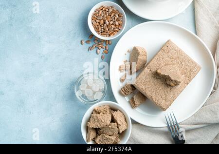 Dolci orientali. Halva, zucchero, semi su sfondo blu con spazio da copiare. Foto Stock