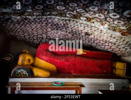 Antica statua colorata del Buddha addormentato nel Tempio di Ravana Vicino alla città di Ella sull'isola dello Sri Lanka Foto Stock