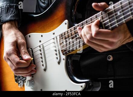 Uomo che suona la chitarra. Primo piano mano che suona la chitarra. Musicista che suona la chitarra, musica dal vivo. Strumento musicale. Chitarra elettrica. Ripetizione di musica rock Foto Stock