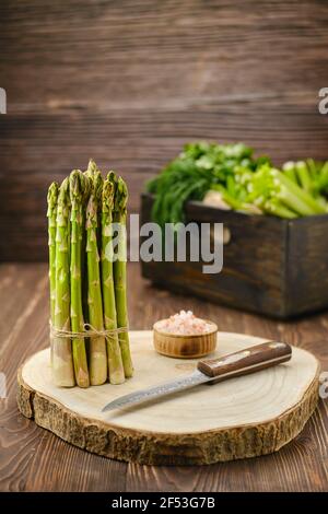 Asparagi freschi su tagliere di legno (messa a fuoco su primo piano) Foto Stock