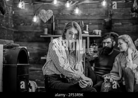 Ragazza con splendidi capelli biondi e angelo faccia seduta accanto al fuoco in inverno sera. Uomo bearded e donna bionda e bevendo VIN brulé Foto Stock