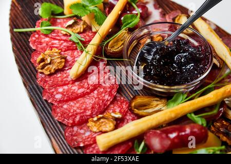 Formaggi assortiti e prelibatezze di carne su tavola di legno. Primo piano, messa a fuoco selettiva Foto Stock