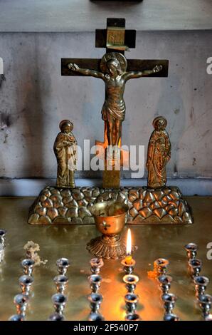 Gesù sulla croce crocifisso con la Vergine Maria e le offerte di candele nella chiesa Tbilisi Georgia Foto Stock