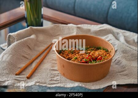 Piatti asiatici da asporto con bastoncini sul tavolo Foto Stock