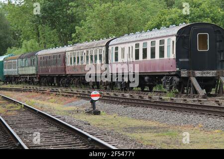 Una fila di carrozze ferroviarie d'epoca in attesa di restauro. Foto Stock