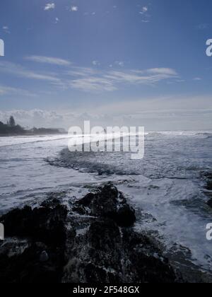 Vista a nord lungo la Gold Coast, Australia, con surf e onde infrangenti che si avvicinano alla spiaggia. Tempo di tempesta incombente. Foto Stock