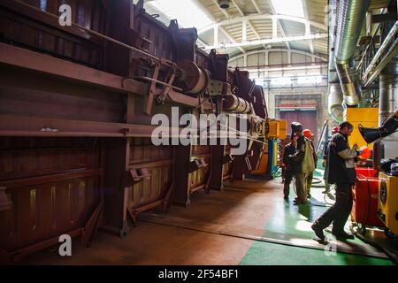 Ekibastuz, regione di Pavlodar, Kazakistan - 28 maggio 2012: Impianto di costruzione di automobili ferroviarie. Tre saldatori in officina. Tubi gialli sistema di aspirazione aria. Foto Stock