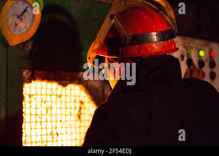 Aksu, regione di Pavlodar, Kazakhstan - maggio 29 2012: Impianto di metallurgia delle leghe metalliche. Lavoratore metallurgico che controlla il processo di fusione. Foto Stock