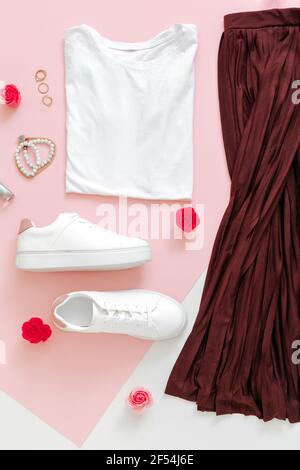 Donna primavera look estate abito gonna scarpe sneakers base tshirt borsa. Vestiti piegati per donne di moda urbano di base vestito con fiori accessori Foto Stock