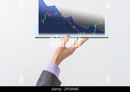 La mano dell'uomo d'affari tiene una visualizzazione del grafico di riserva in uno schermo visivo. Mostra segni di calo delle scorte nel 2021 con un indicatore grafico. Concetti di Foto Stock