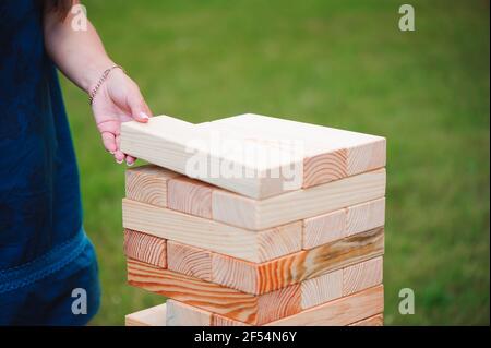 La torre da blocchi di legno e di mano d'uomo prendere un blocco. Foto Stock