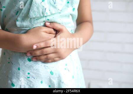 bambina che soffre di mal di stomaco primo piano. Foto Stock