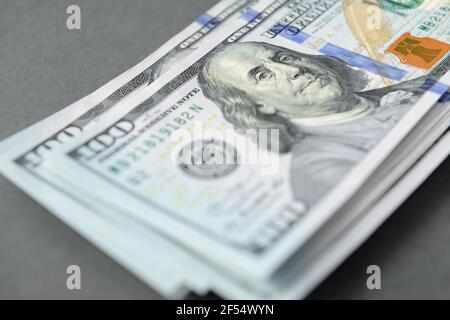 Cumulo di un centinaio di banconote da dollaro come sfondo di denaro. Le nuove fatture del dollaro si diffondono nel concetto finanziario Foto Stock