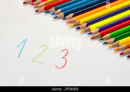 Apprendimento di colori e numeri con matite colorate su carta bianca. Foto Stock