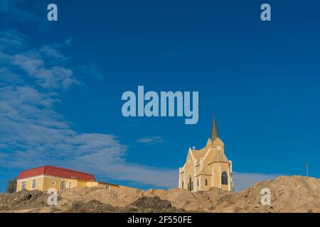 Bella vista panoramica della chiesa coloniale tedesca protestante Felsenkirche a Luederitz, Luderitz in Namibia, Africa. Foto Stock