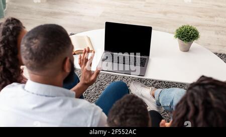 Famiglia nera con videocall utilizzando pc con schermo vuoto Foto Stock