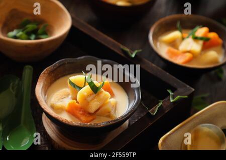 Kolak Pisang Ubi. Stufato dolce indonesiano di banana e patate dolci nella zuppa di latte di cocco Foto Stock