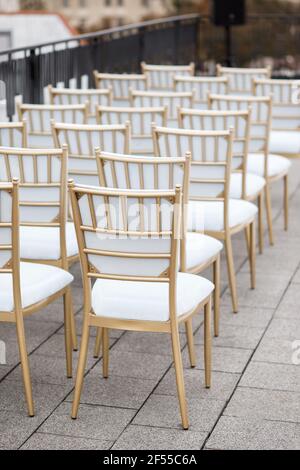 Molte sedie bianche sono allineate per gli ospiti sul tetto della casa per festeggiare. Celebrazione Foto Stock