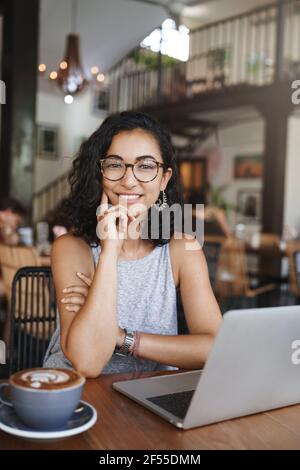 Verticale esterno ha girato giovane insegnante in bicchieri con capelli ricci, avendo incontro con lo studente, tutor insegnando persone al bar, bere caffè, preparare Foto Stock