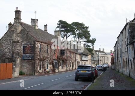 Una strada con case e un pub locale chiamato il Wheatsheaf a Northleach, Gloucester, Inghilterra Foto Stock