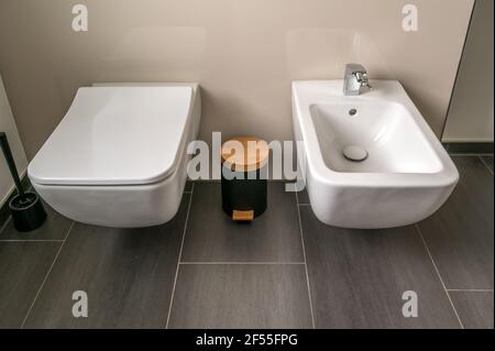 Attrezzature moderne in un nuovo bagno con wc e bidet accanto ad esso Foto Stock