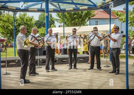 DOMZALE, SLOVENIA - 21 giu 2019: Gli anziani intrattengono i visitatori del festival suonando in orchestra del vento nel parco Foto Stock