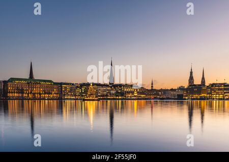 Germania, Amburgo, architettura cittadina che riflette nel lago di Binnenalster al tramonto Foto Stock