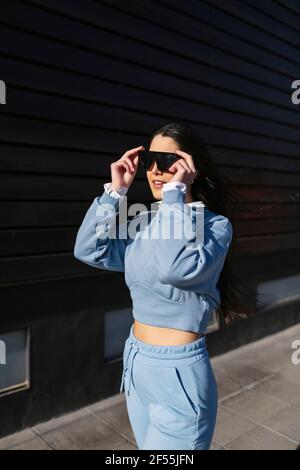 Donna sorridente con occhiali da sole Foto Stock