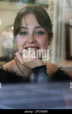 Donna sorridente dietro windowpane Foto Stock