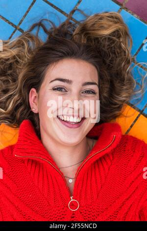 Felice giovane donna sdraiata sul sentiero Foto Stock