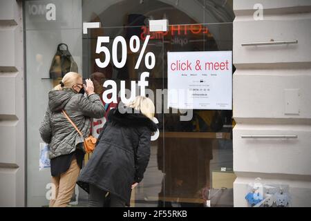 Monaco, Germania. 23 marzo 2021. Foto oggetto: Shopping, Shopping Clicca e incontra a Monaco, appuntamento shopping, accesso e shopping dopo aver fatto un appuntamento, i clienti sono autorizzati a fare acquisti nel negozio. Appuntamenti, registrati. Un cartello appende di fronte a un negozio a Muenchen con l'avviso di fissare un appuntamento online-due donne stand di fronte a una vetrina e guardare in un negozio. sconto del 50%, sconti, sconti. | utilizzo in tutto il mondo credito: dpa/Alamy Live News Foto Stock