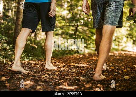 Uomini in pantaloncini che camminano nella foresta Foto Stock