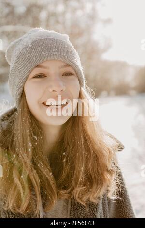 Ritratto di bella ragazza teenage che indossa cappello a maglia sorridente a. fotocamera Foto Stock