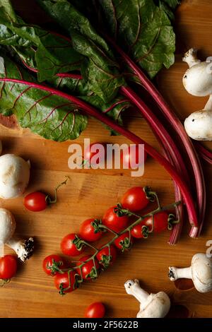 Pomodoro rosso e ciliegia su tavola di legno Foto Stock